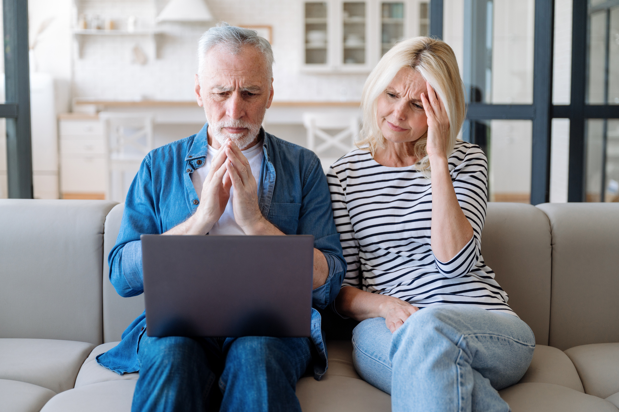 Couple sitting on a couch worried