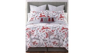 A three-piece white, gray, and red quilted Christmas bedding set that has reindeers and and snowflake designs.