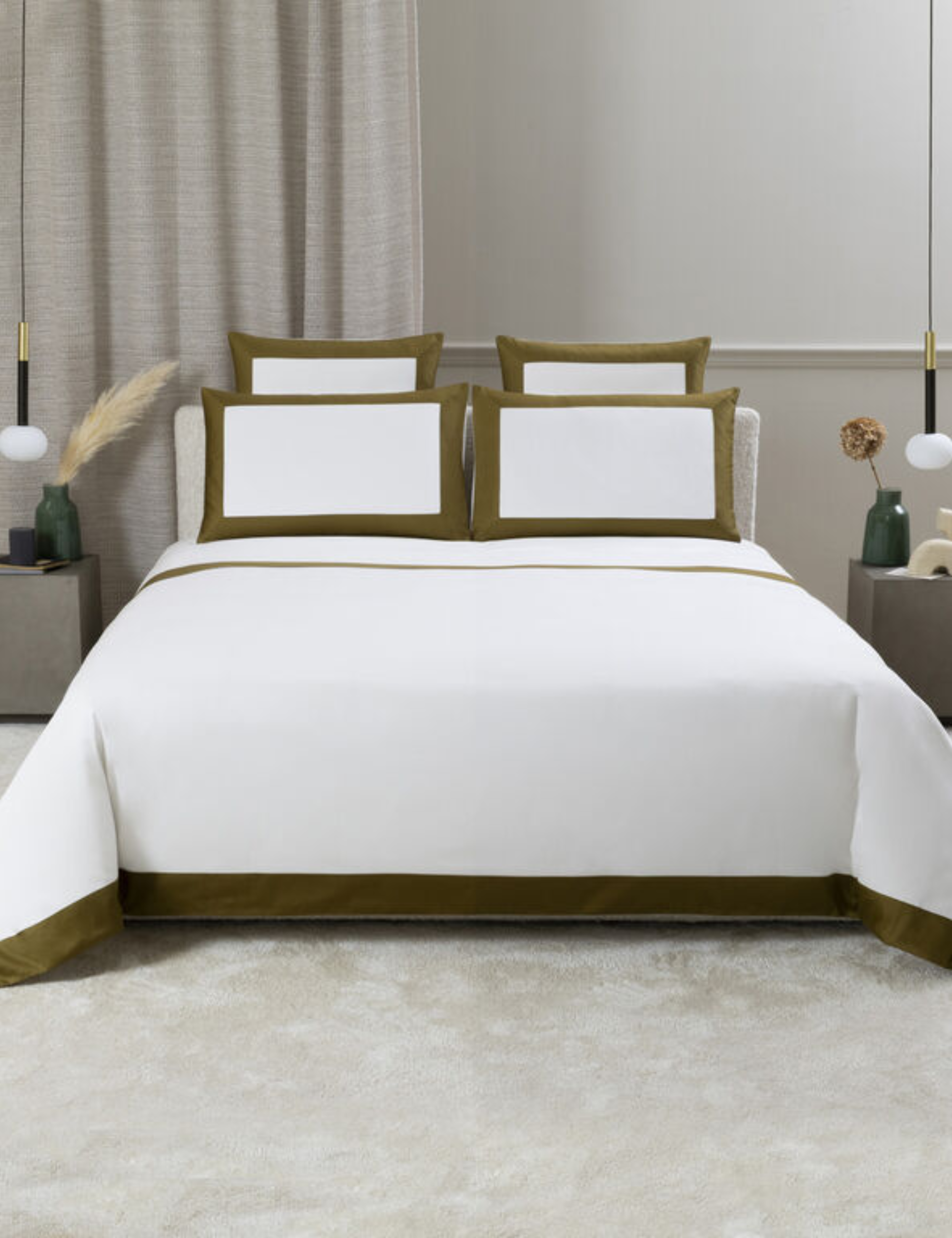 Bold bordered Frette bedsheets styled inside of a neutral bedroom