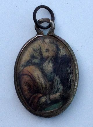 This metal locket is covered with glass and decorated with the image of Moses holding the Ten Commandments.