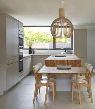 Kitchen with neutral cabinets, island and dining table