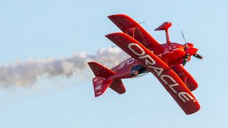 Red plane flying in the sky with Oracle written on it