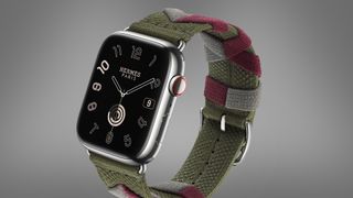 An Apple Watch with an optional strap on a grey background