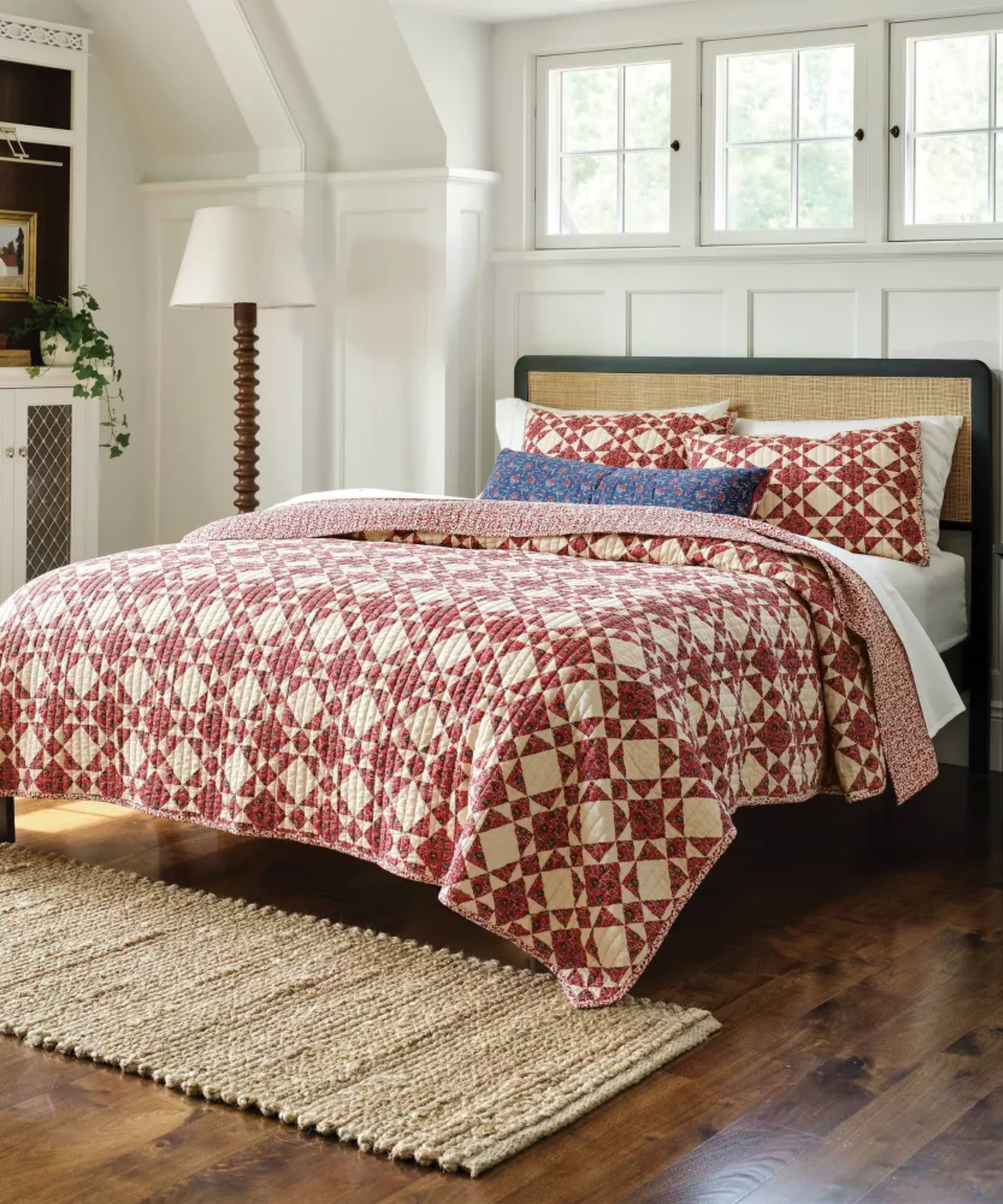 a bedroom with a red quilt on the bed