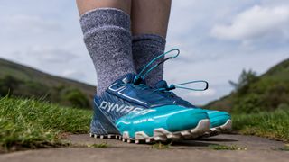 A pair of feet and lower legs wearing hiking shoes and BAM Twist Walking Socks.