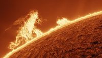 close up view of the sun shows a tall structure resembling 'Godzilla' "walking" along the edge of the sun and breathing its atomic breath!
