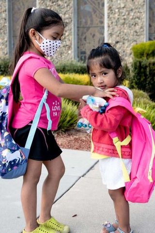 two girls wearing new backpacks