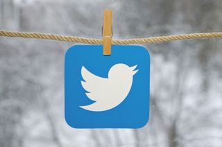 Twitter logo hanging on a clothes line by a clothes peg