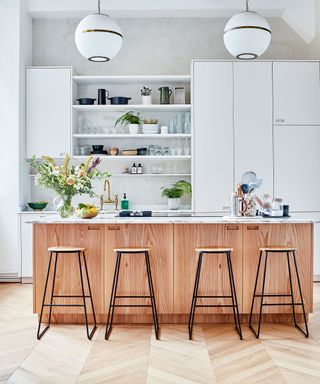 White kitchen with wooden island and flooring