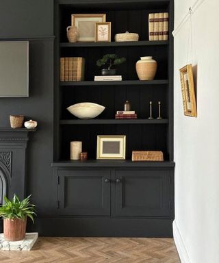 living room with black wall and built-in shelving with neutral decor