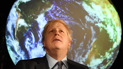 Boris Johnson in front of a projection of Earth