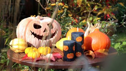 outdoor halloween decor ideas: pumpkins and candles in set-up from nobunto