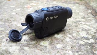 Pulsar Axion XQ30 PRO night vision monocular on a stone surface