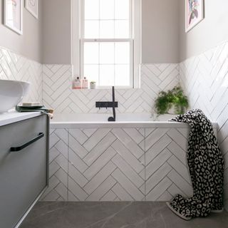 White bathroom with tiled walls and bath