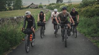 A group of bikepackers riding along a road