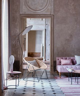 A classic and playful large living room picture with plaster walls and a rattan chair.