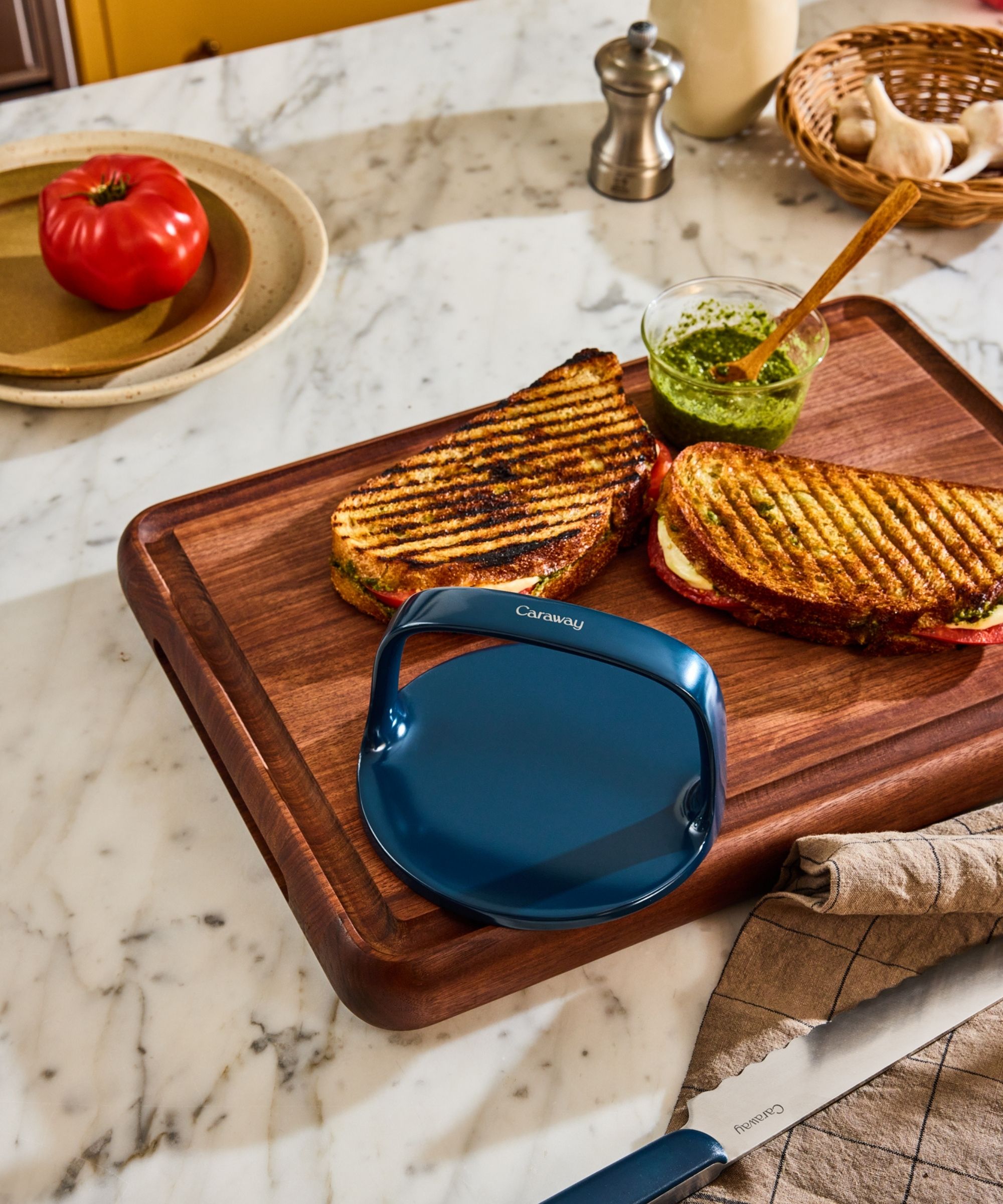 Blue grill press on chopping board with toasted sandwiches
