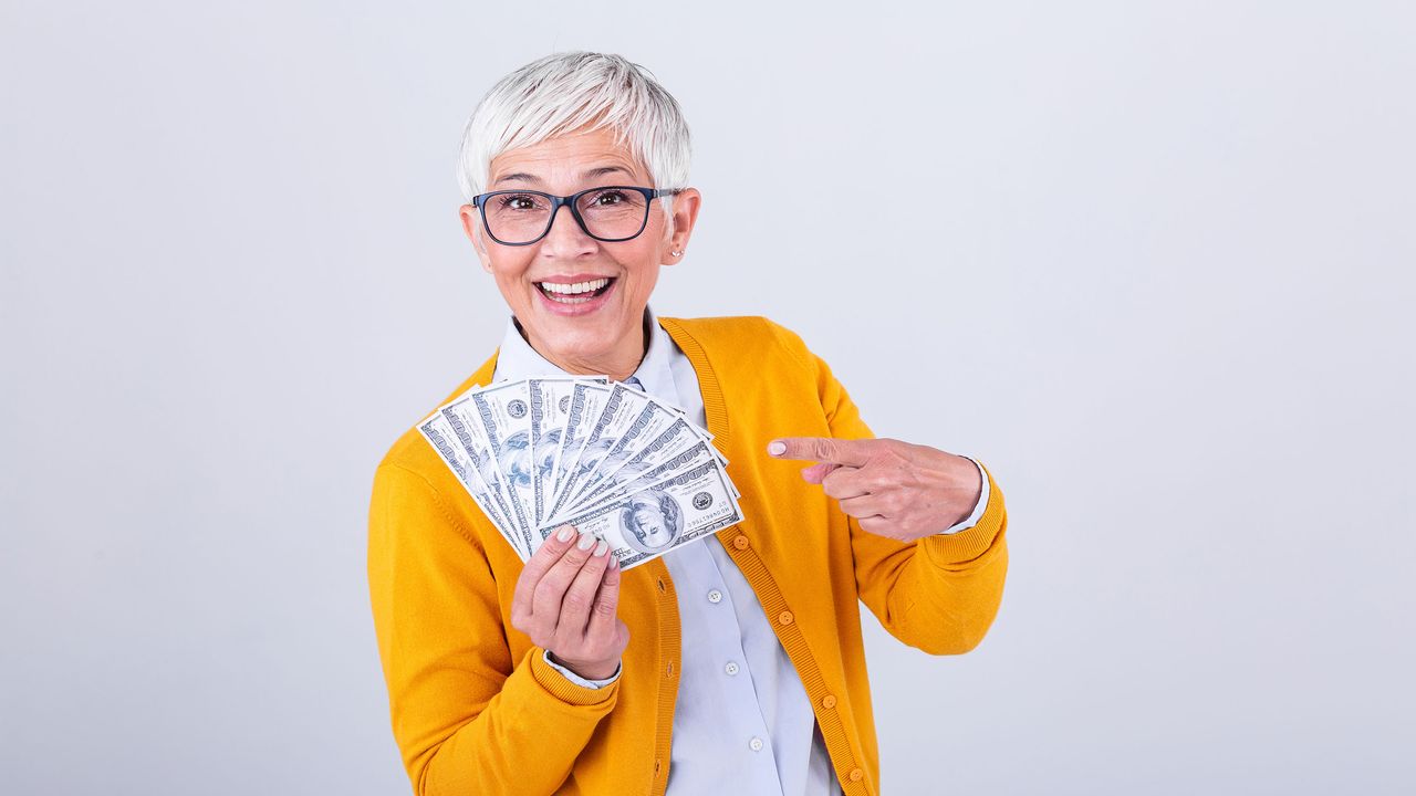 picture of elderly woman holding and point to cash