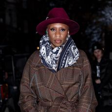 Cynthia Erivo wearing a trench coat and white boots