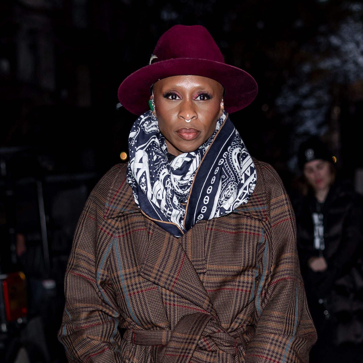Cynthia Erivo wearing a trench coat and white boots