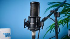 the Shure sm4 condenser musician microphone photographed against a blue background with a physical magnetic pop filter