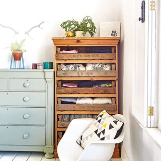 Wooden linen cupboard with folded clothes on shelves
