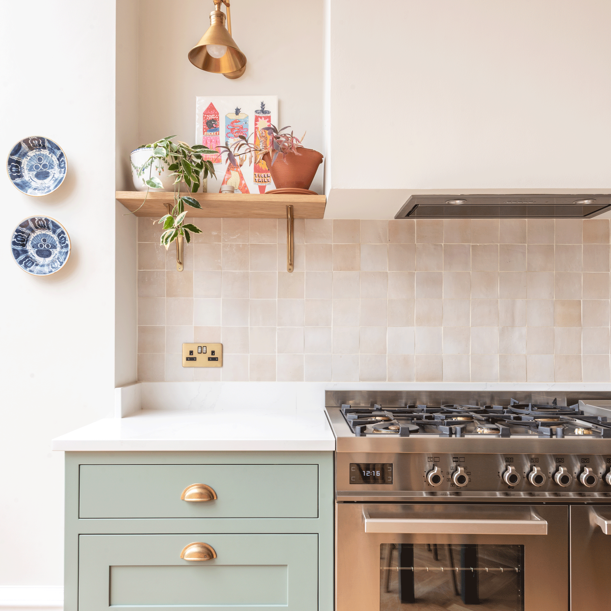 a kitchen with sage green cabinets, a range cooker, tiled splashback and open shelving