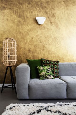 metallic wall in a living room with grey sofa and lattice wood shade