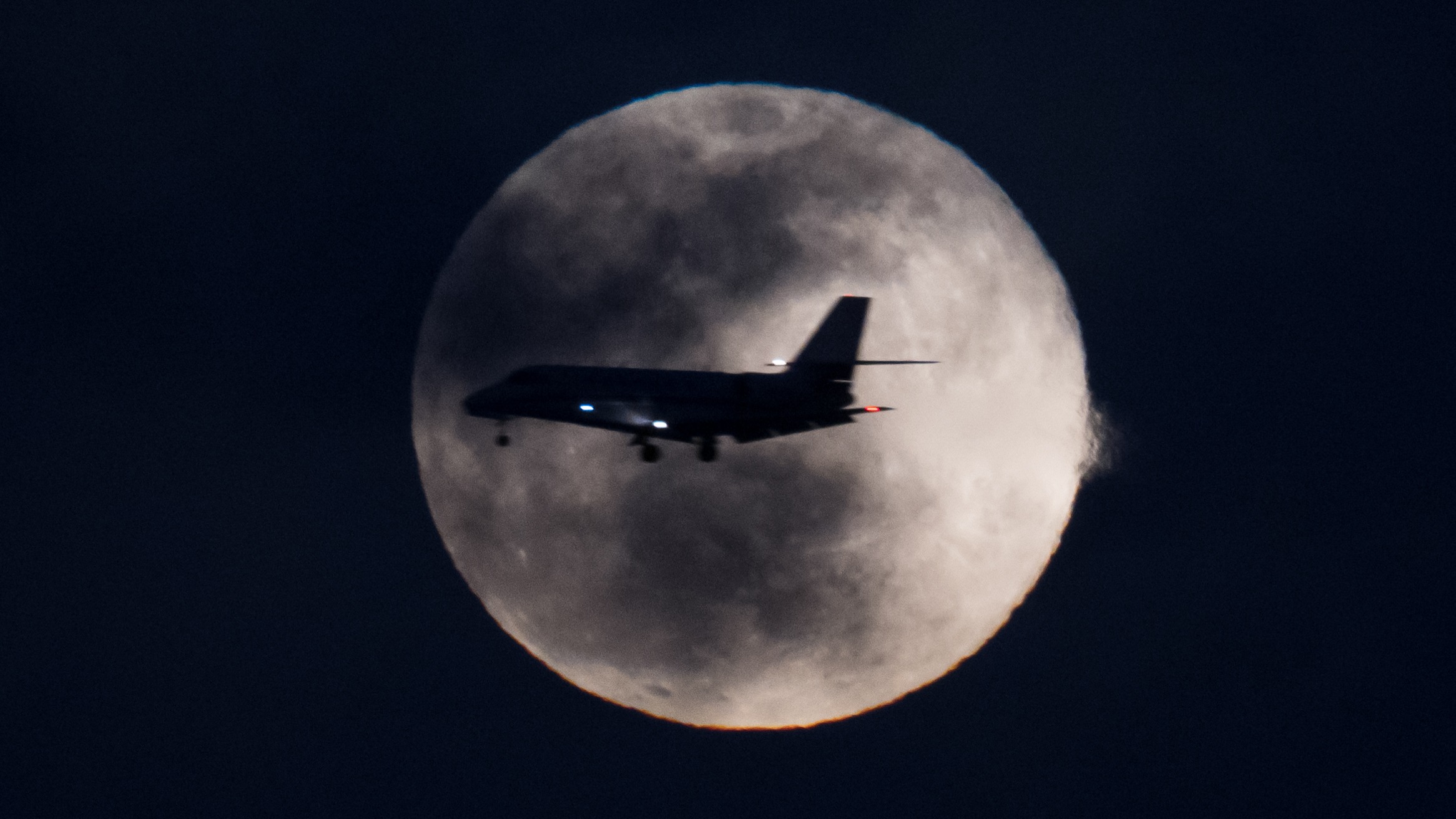 airplane in front of full moon