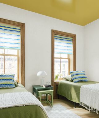 white bedroom with yellow ceiling and twin beds