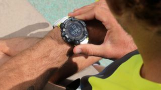 Casio G-Shock GBD-H1000 review: person looking at the watch on the side of a pool