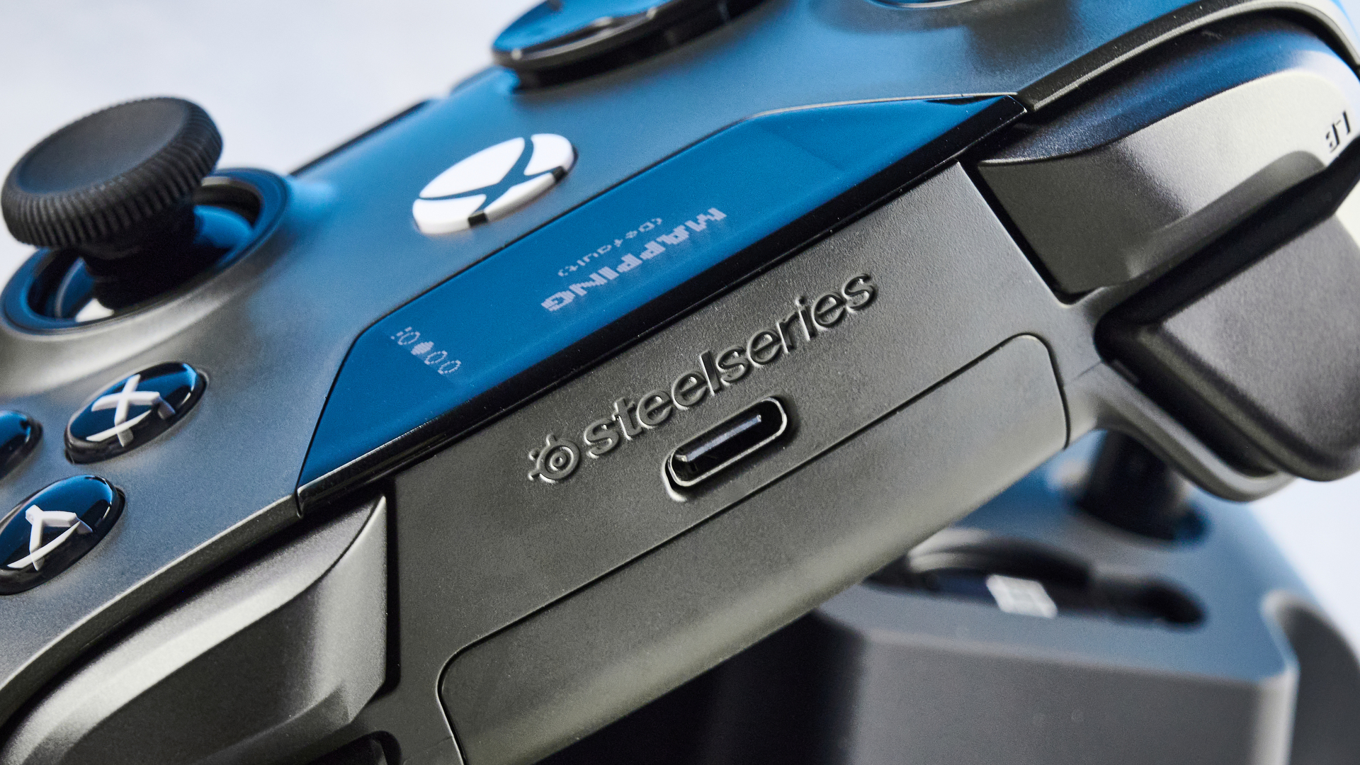 The SteelSeries Aeon Pro on a stone surface against a blue background