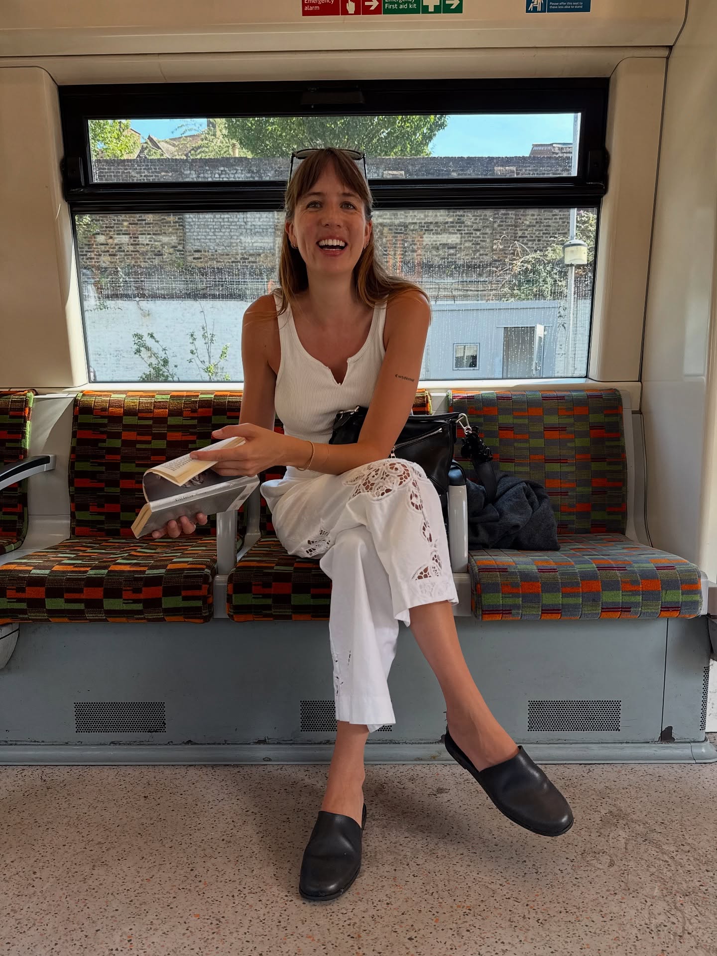 An image of @lizzyhadfield showcasing how to wear pedal pushers with white embroidered trousers, a white tank and slip-on mules.