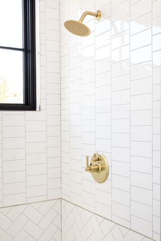 Shower with white tile with different laying patterns above and below