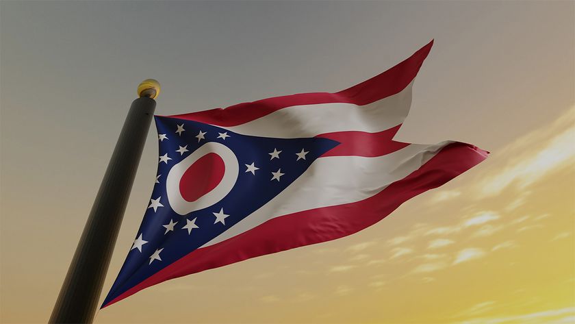 Red, white, and blue flag of Ohio flying at dusk