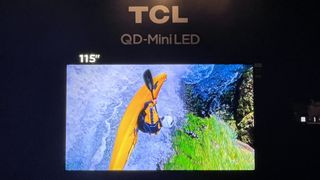 TCL QM8 115-inch TV showing image of white water kayaking