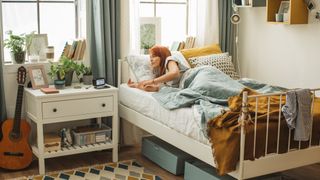 Girl waking up in a brightly lit dorm room bed
