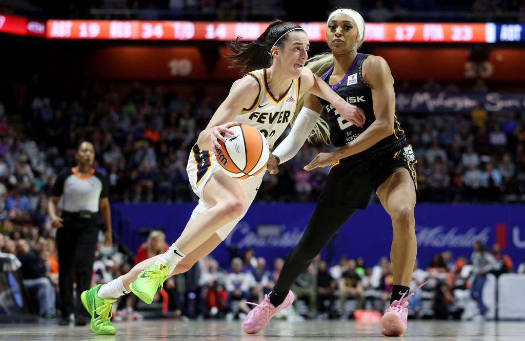 Caitlin Clark #22 of the Indiana Fever heads for the net as DiJonai Carrington #21 of the Connecticut Sun defends in the second half at Mohegan Sun Arena on May 14, 2024 in Uncasville, Connecticut. 