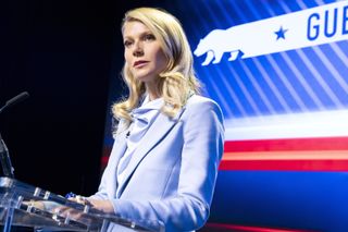 gwyneth paltrow speaks at a podium at a political event in the politician