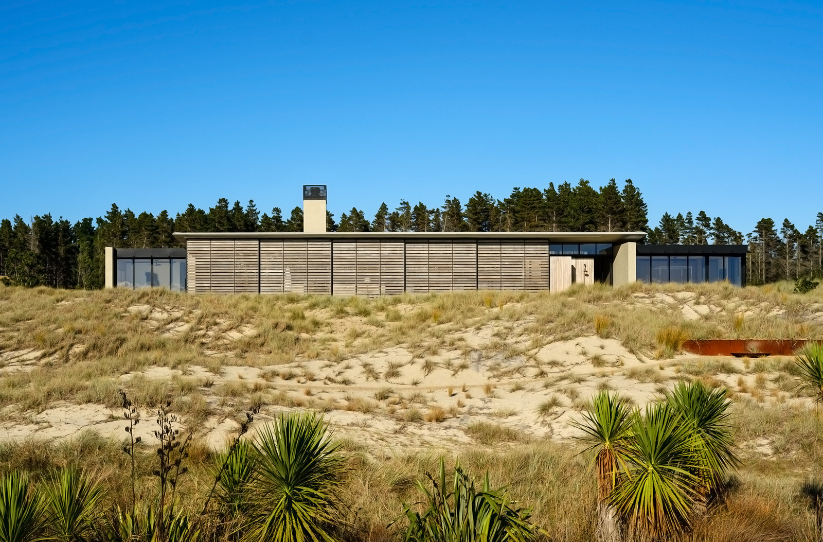 Te Whare Tupu Kirikiri, a New Zealand house in a rugged beach