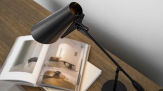 black desk lamp shining on lifestyle book