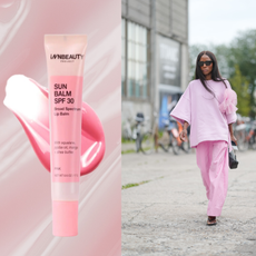 An SPF lip balm in front of a glossy pink background next to a woman wearing all pink.