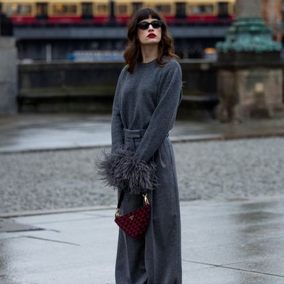 grey jumpers - woman wearing grey wool jumper with feather cuffs and red accessories 1817248191