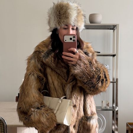 Lauren Caruso posing in mirror wearing fur coats 