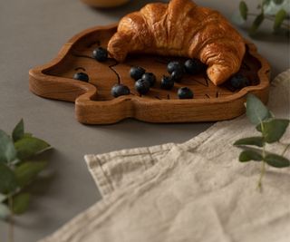 A napkin beside a plate and croissant