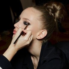 blonde model backstage having smokey eye makeup applied