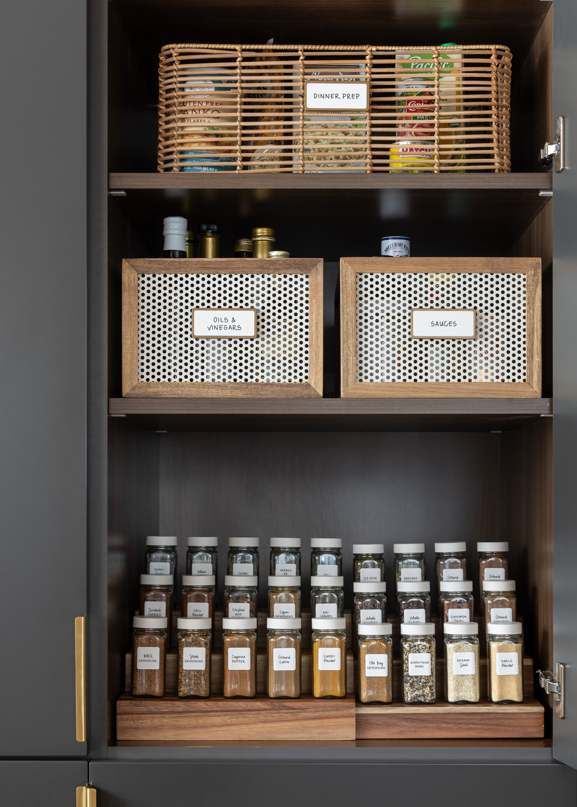 A kitchen cabinet with shelf risers and spice jars
