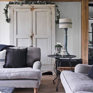 two pale grey sofas in front of white cupboard