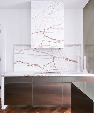 Modern white kitchen with marble extractor hood and wood cabinets