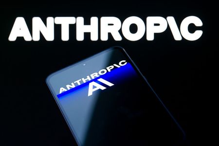 The Anthropic AI logo is displayed on a mobile phone with the company branding visible in the background.